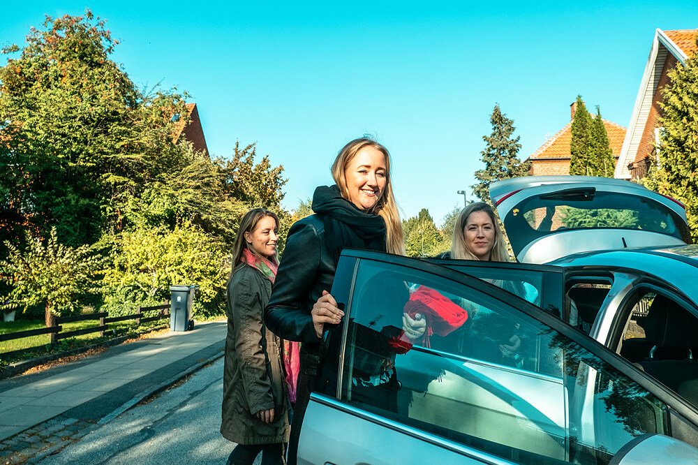 Familie stiger ind i bilen