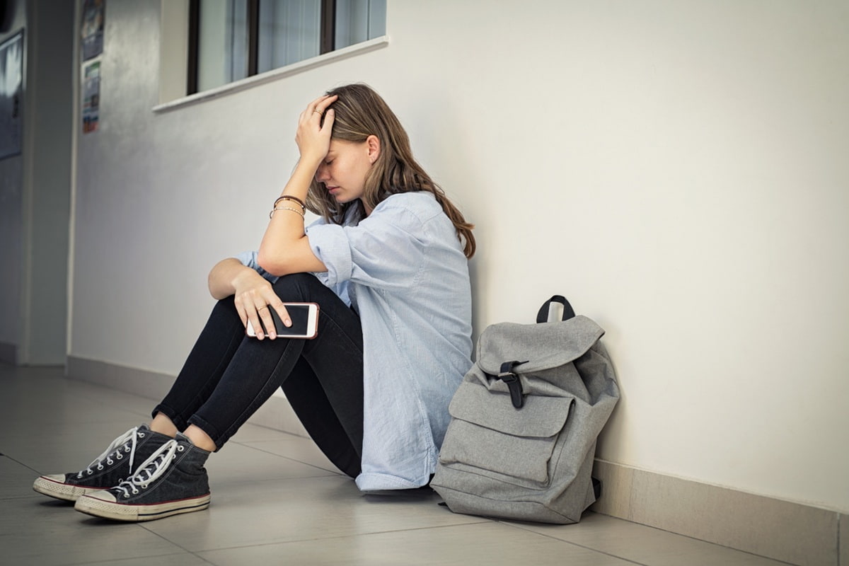 Ung person, der sidder med sin smartphone