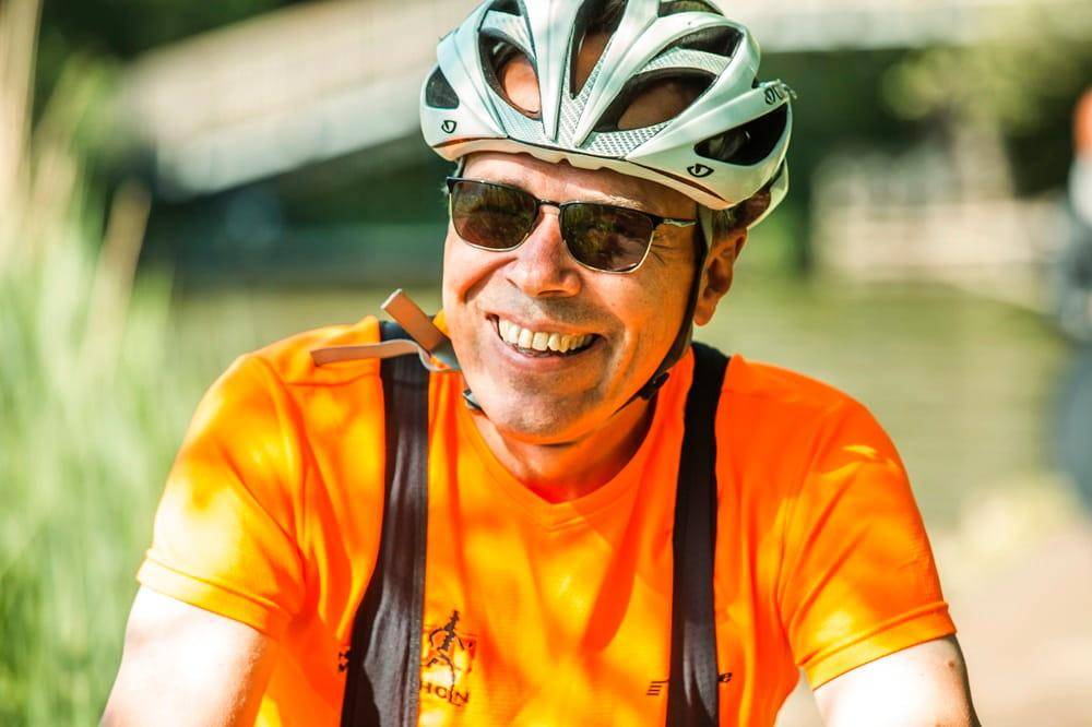 Mand med cykelhjelm, der overvejer en elcykel og tænker på elcykelforsikring